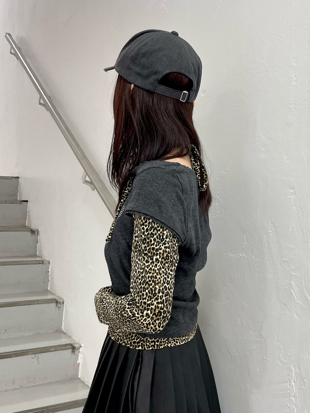 ブラック系のTシャツ/カットソー、ブラック系のスカート、ブラック系のハンドバッグを着用したレディースの冬コーディネートの6枚目の写真