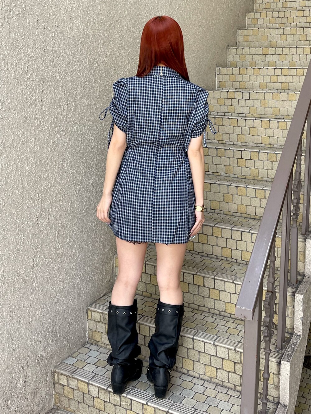ブルー系のワンピース、ブラック系のブーツ、ゴールド系のネックレスを着用したレディースの春コーディネートの4枚目の写真