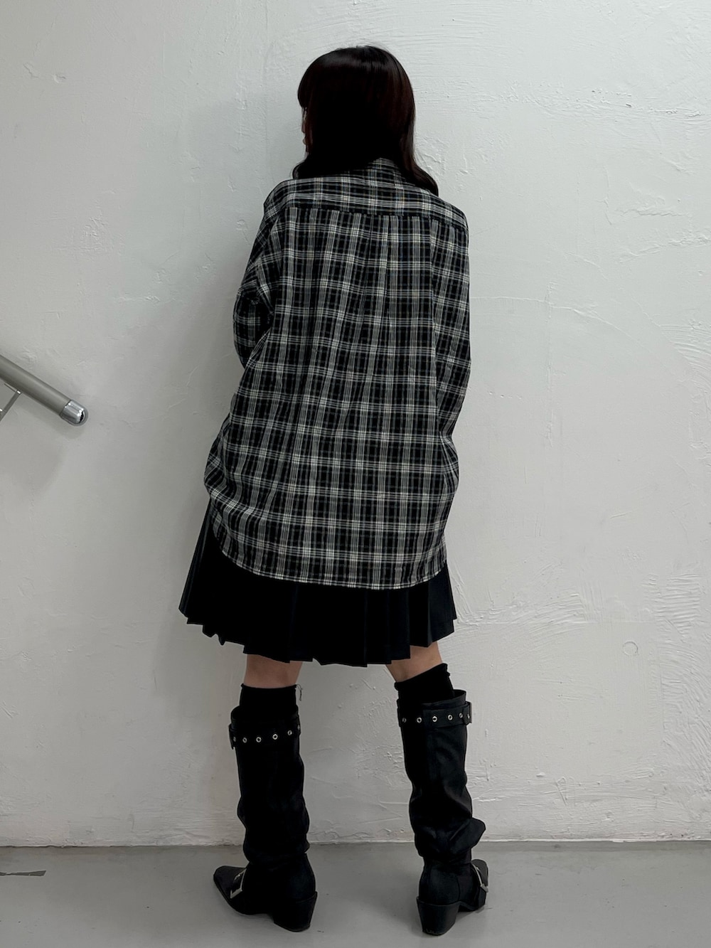 ブラック系のシャツ/ブラウス、ブラック系のスカート、ブラック系のブーツを着用したレディースの春コーディネートの4枚目の写真