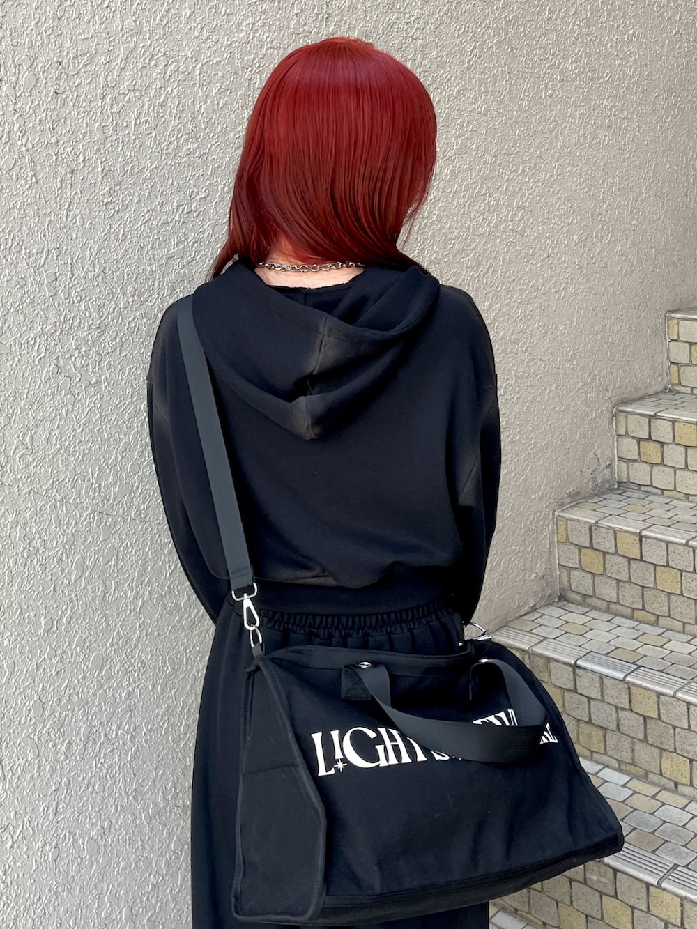 ブラック系のパーカー、ブラック系のスウェットパンツ、ブラック系のボストンバッグを着用したレディースの春コーディネートの7枚目の写真