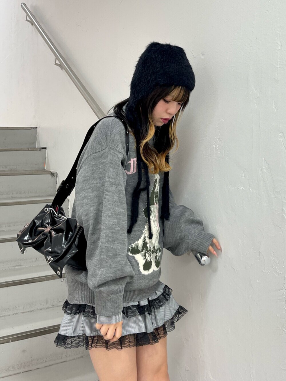 グレー系のニット/セーター、ブラック系のシャツ/ブラウス、ブラック系のブーツを着用したレディースの秋コーディネートの5枚目の写真