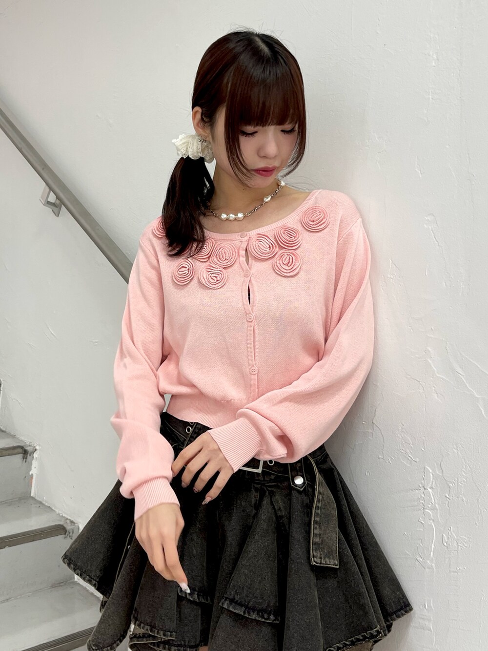 ピンク系のニット/セーター、ブラック系のデニムスカート、ブラック系のブーツを着用したレディースの春コーディネートの5枚目の写真