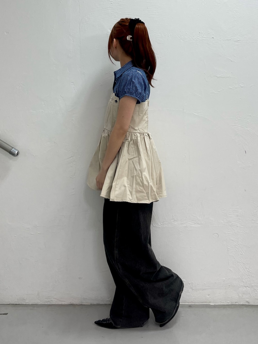 ホワイト系のチュニック、ブラック系のデニムパンツ、ブラック系のパンプスを着用したレディースの春コーディネートの3枚目の写真