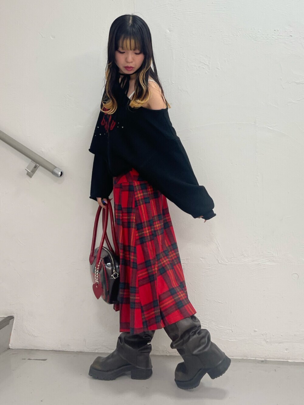 ブラック系のボストンバッグ、ブラック系のブーツ、ブラック系のニット/セーターを着用したレディースの秋コーディネートの2枚目の写真