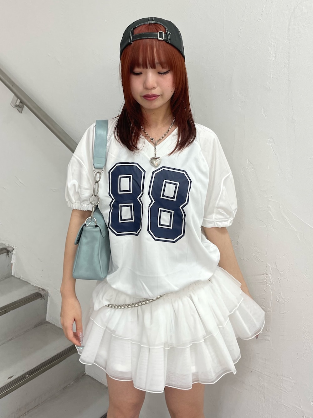 ホワイト系のワンピース、ブルー系のハンドバッグ、ブラック系のブーツを着用したレディースの春コーディネートの5枚目の写真
