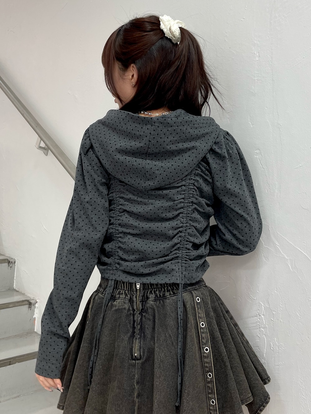 ブラック系のパーカー、ブラック系のデニムスカート、ブラック系のブーツを着用したレディースの春コーディネートの7枚目の写真