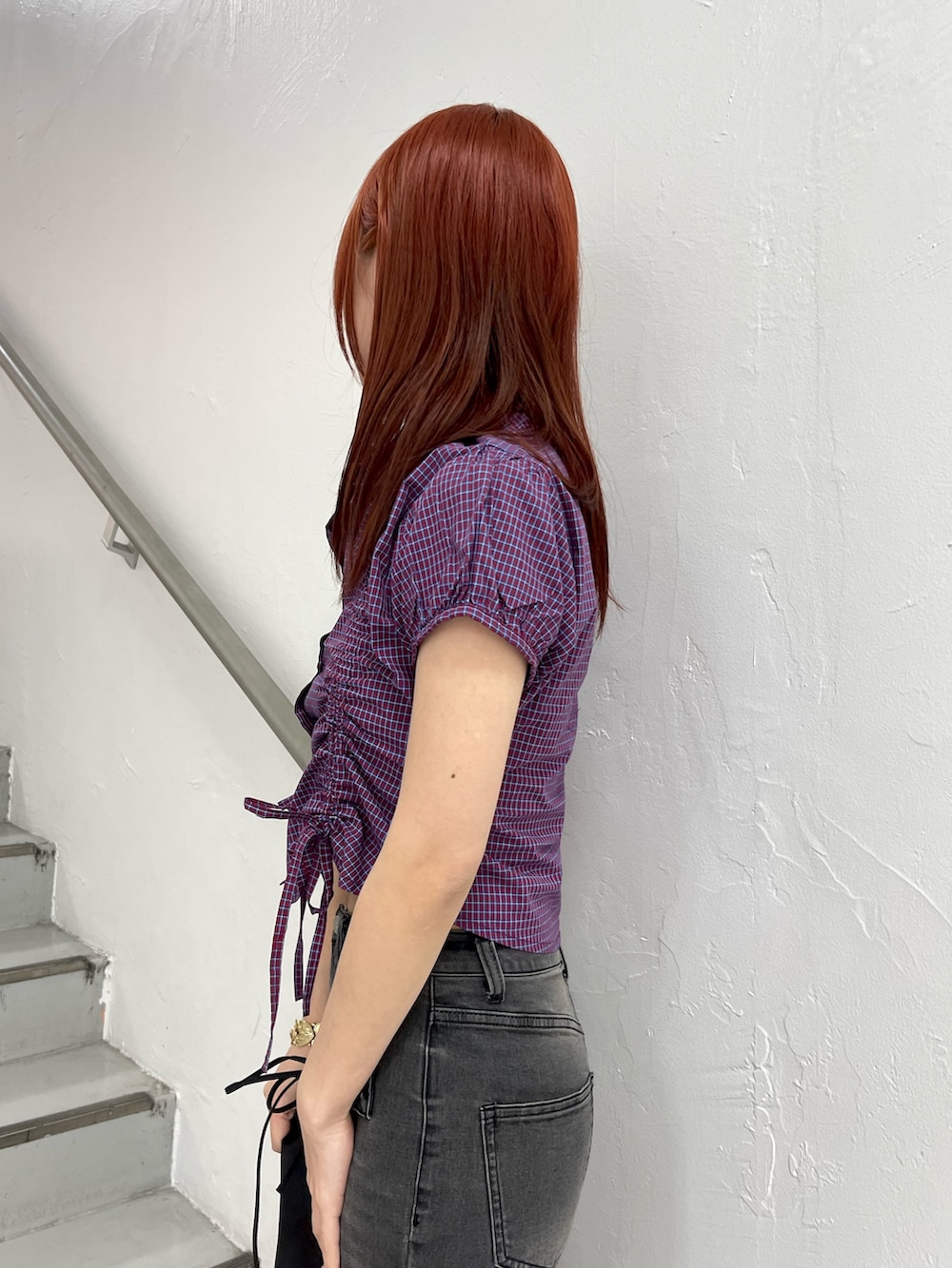 レッド系のシャツ/ブラウス、ブラック系のデニムパンツ、ブラック系のボストンバッグを着用したレディースの春コーディネートの6枚目の写真