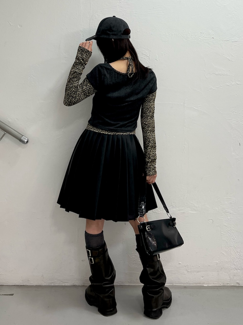 ブラック系のTシャツ/カットソー、ブラック系のスカート、ブラック系のハンドバッグを着用したレディースの冬コーディネートの4枚目の写真