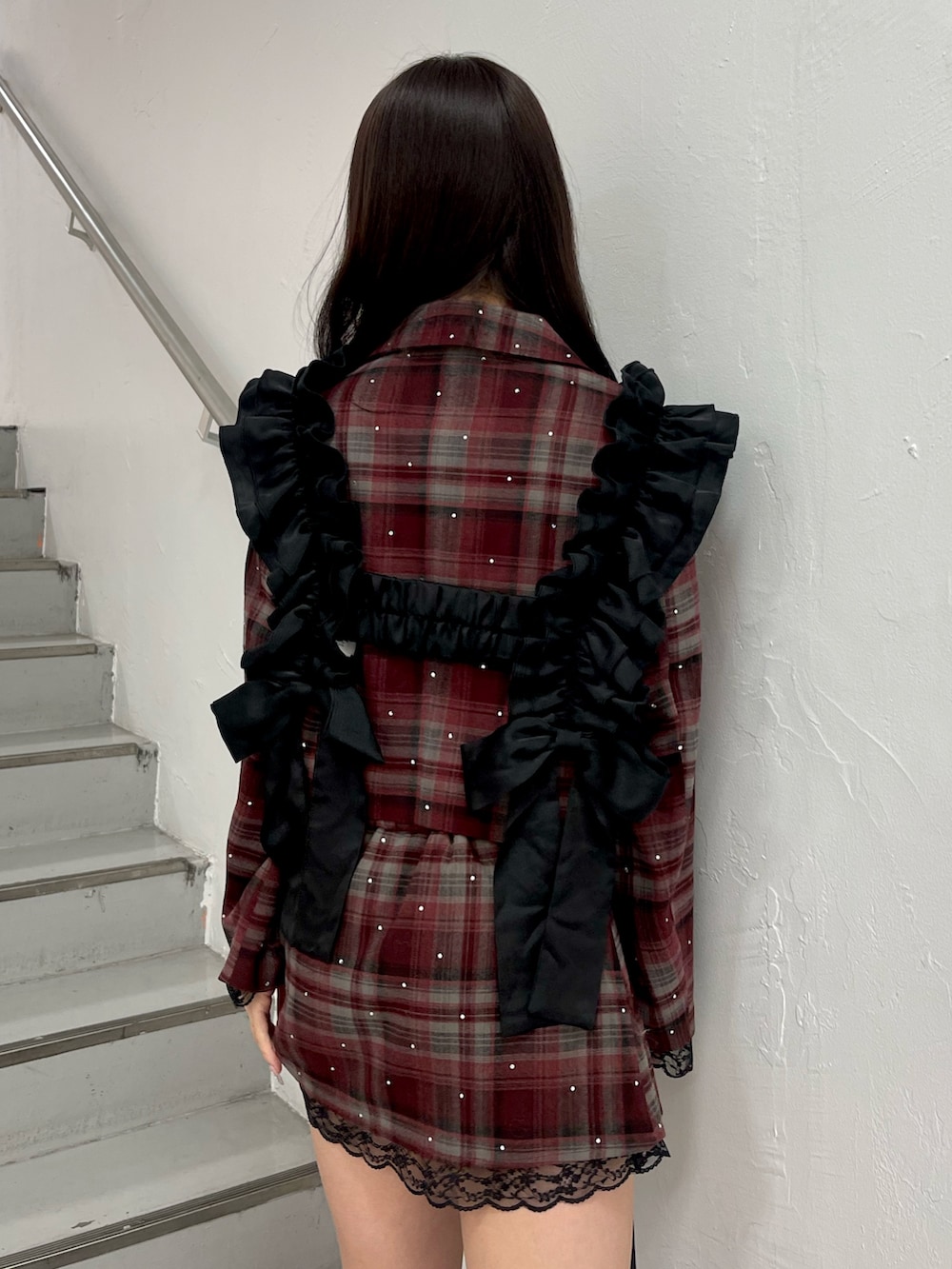 レッド系のテーラードジャケット、レッド系のスカート、ブラック系のショルダーバッグを着用したレディースの冬コーディネートの6枚目の写真