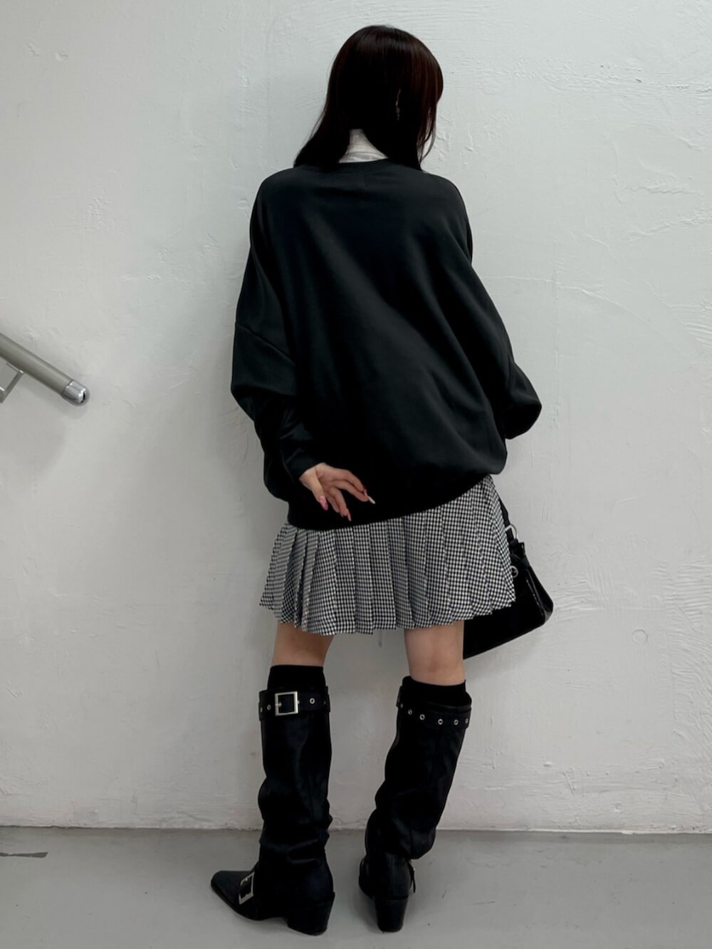 ブラック系のハンドバッグ、ブラック系のブーツ、ホワイト系のシャツ/ブラウスを着用したレディースの冬コーディネートの4枚目の写真