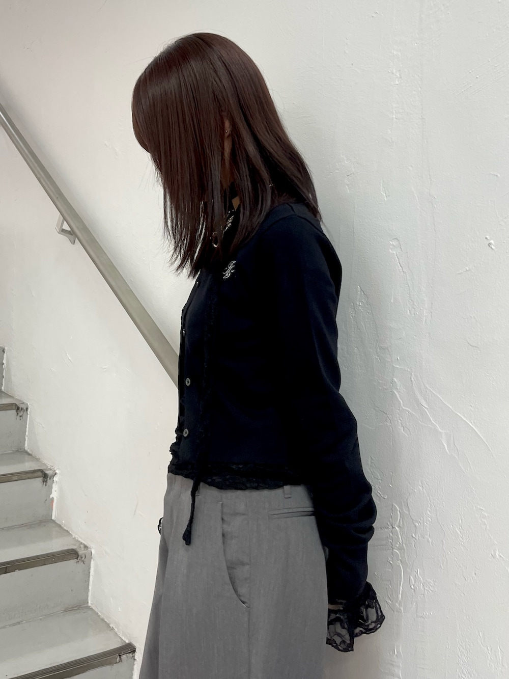 ブラック系のカーディガン/ボレロ、ブラック系のTシャツ/カットソー、グレー系のスラックスを着用したレディースの冬コーディネートの6枚目の写真