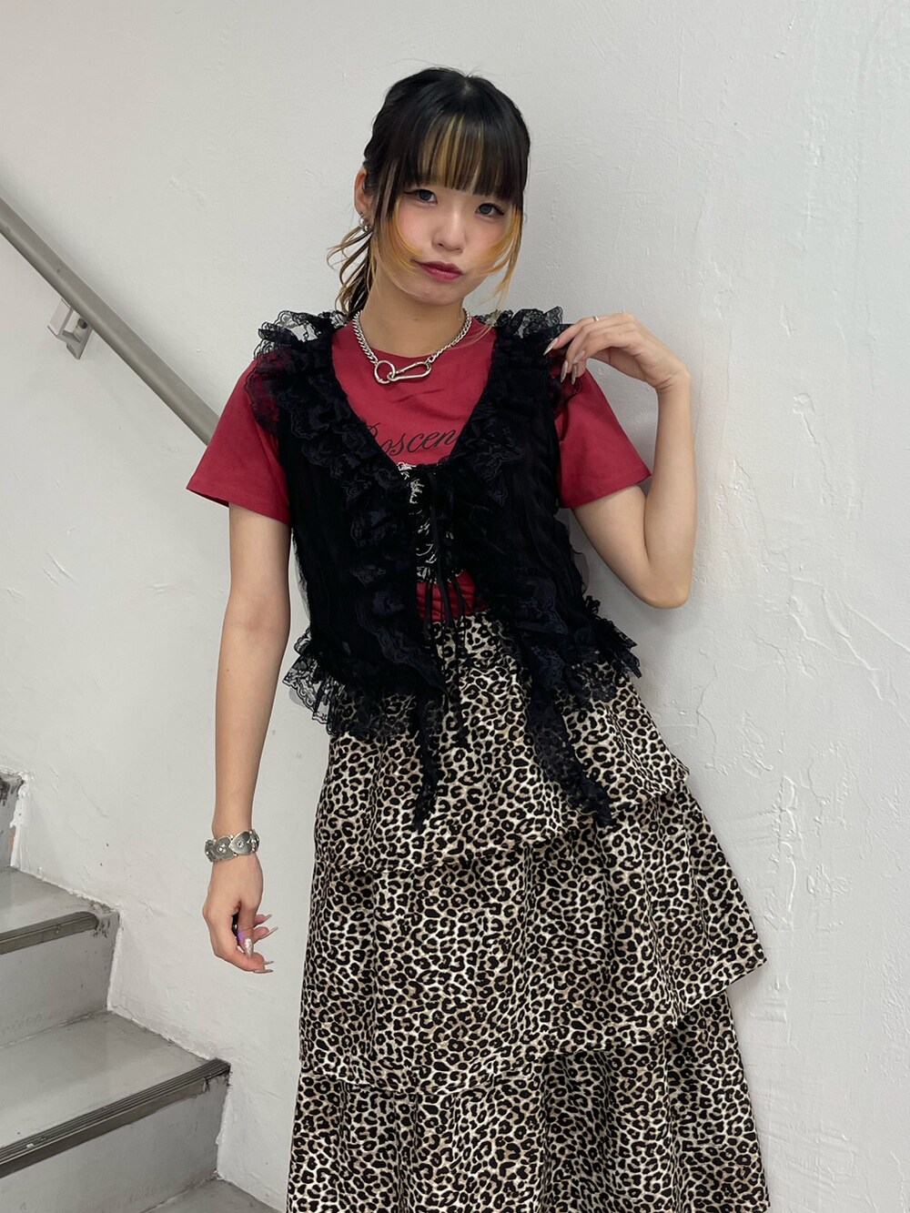 ブラウン系のスカート、ブラック系のブーツ、ブラック系のベストを着用したレディースの夏コーディネートの4枚目の写真