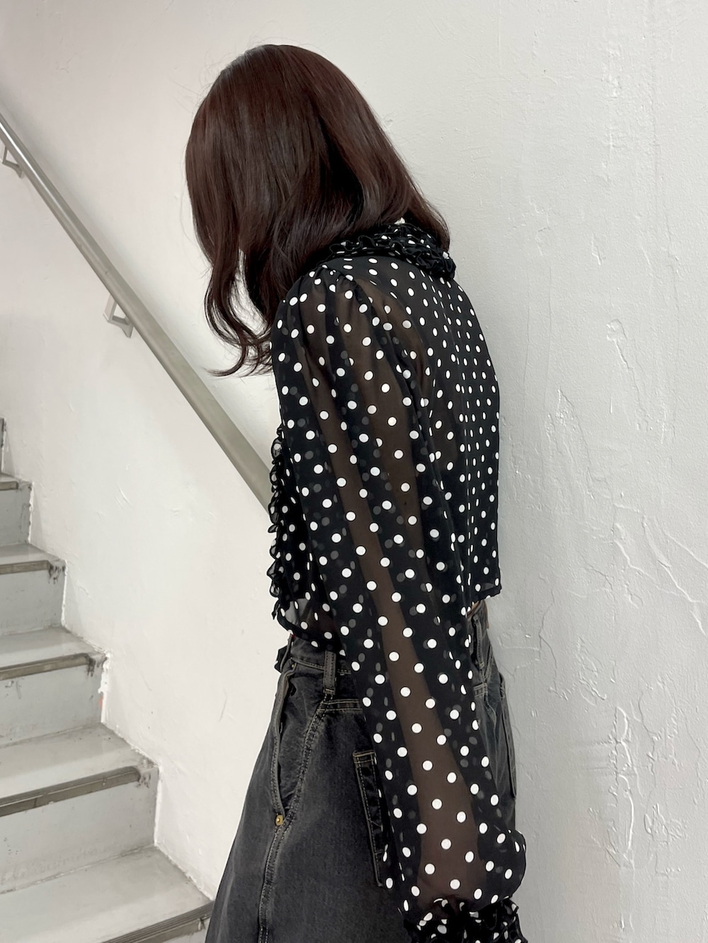 ブラック系のデニムパンツ、ブラック系のハンドバッグ、ブラック系のパンプスを着用したレディースの春コーディネートの6枚目の写真