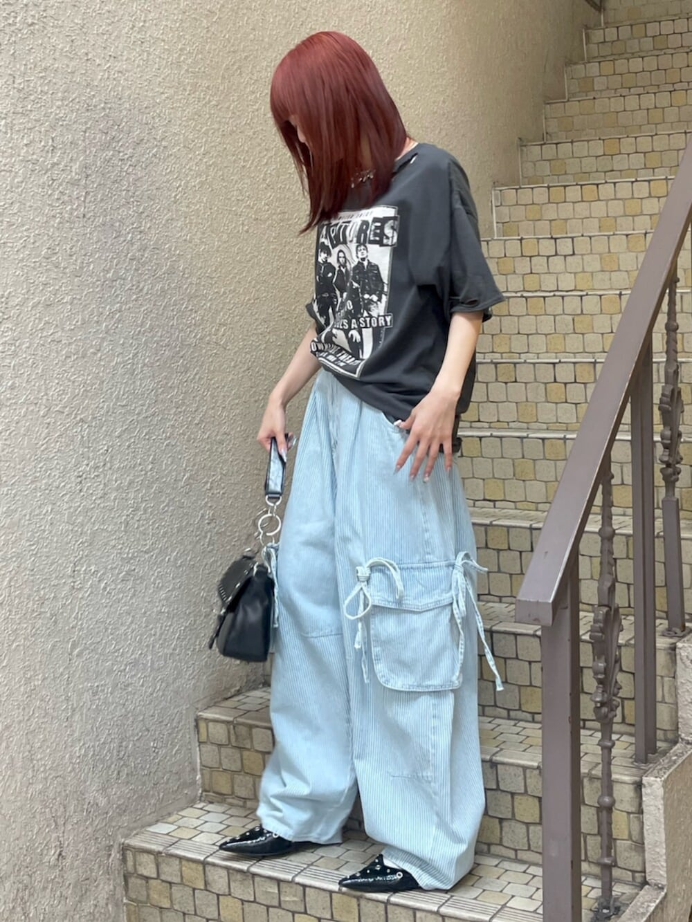 ブラック系のパンプス、ブラック系のハンドバッグ、ブラック系のTシャツ/カットソーを着用したレディースの春コーディネートの2枚目の写真