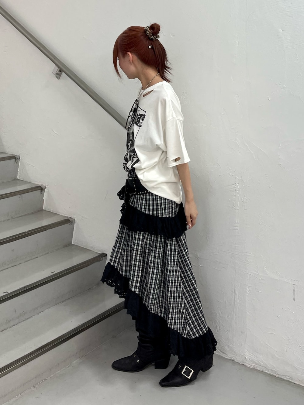ブラック系のスカート、ブラック系のブーツ、ホワイト系のTシャツ/カットソーを着用したレディースの春コーディネートの3枚目の写真