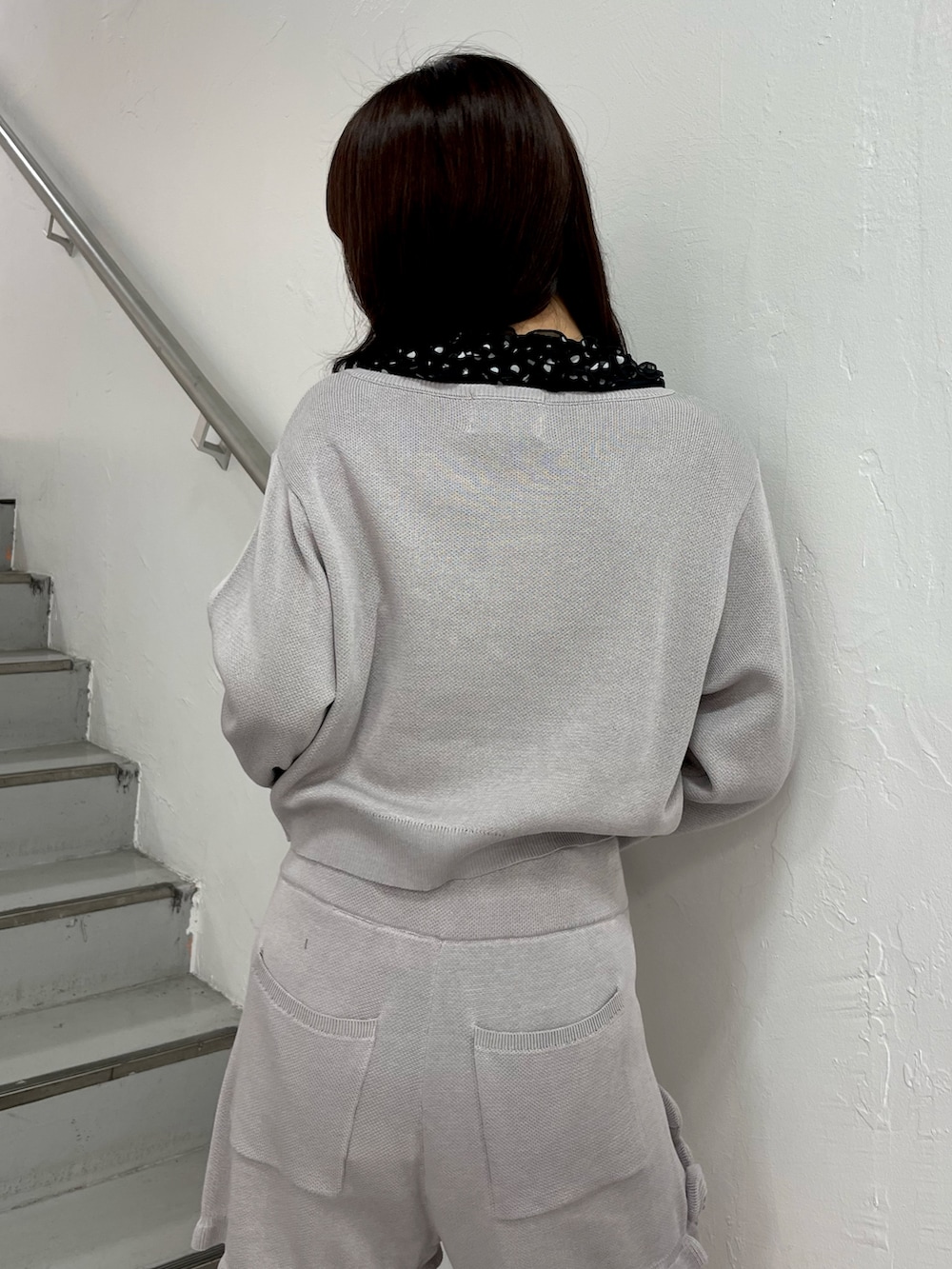 グレー系のニット/セーター、グレー系のその他パンツ、ブラック系のシャツ/ブラウスを着用したレディースの春コーディネートの7枚目の写真