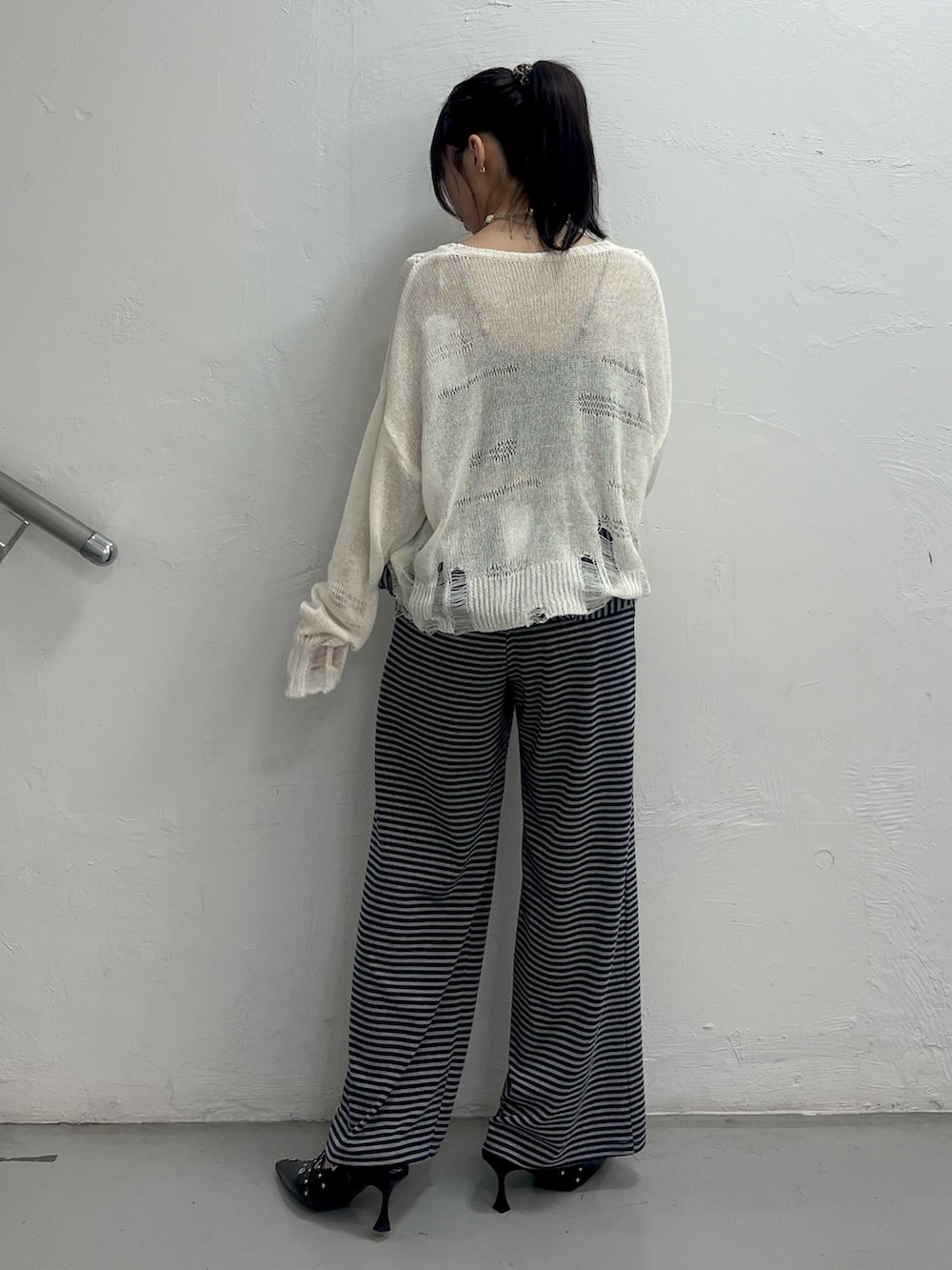 ホワイト系のニット/セーター、ブルー系のスウェットパンツ、ブラック系のパンプスを着用したレディースの春コーディネートの4枚目の写真