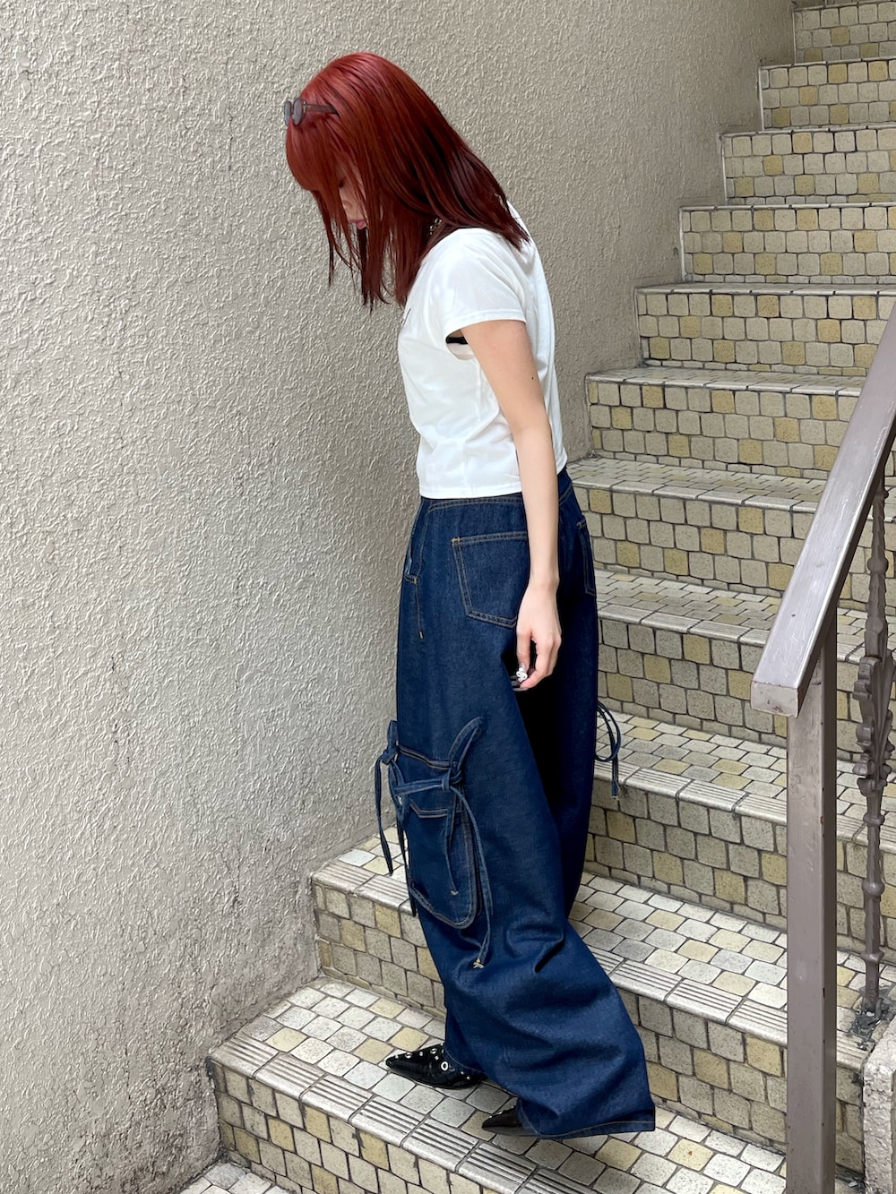 ブルー系のデニムパンツ、ホワイト系のTシャツ/カットソー、ブラック系のパンプスを着用したレディースの春コーディネートの3枚目の写真