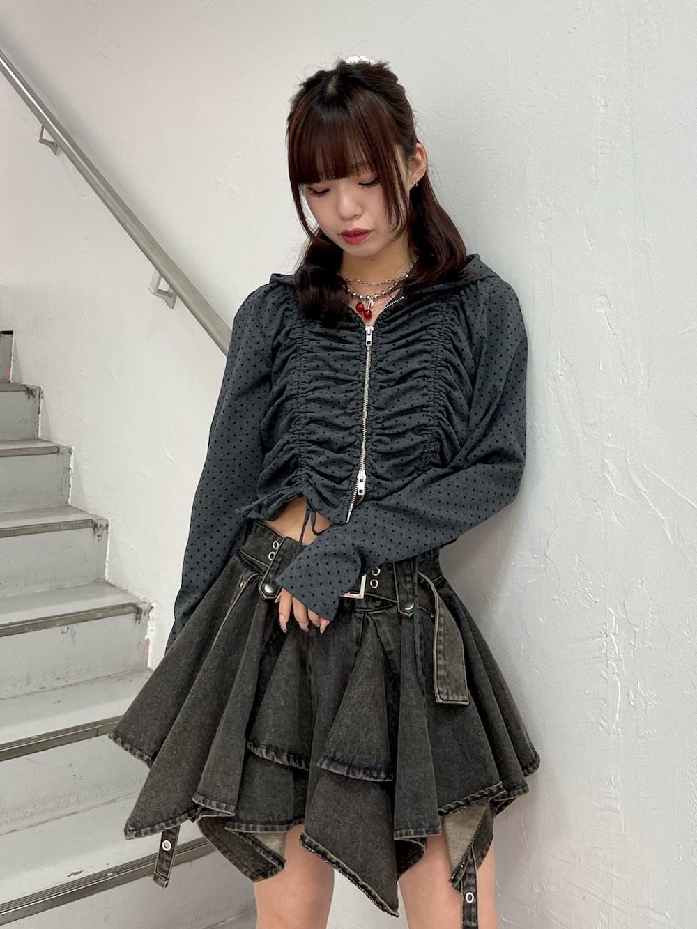 ブラック系のパーカー、ブラック系のデニムスカート、ブラック系のブーツを着用したレディースの春コーディネートの5枚目の写真