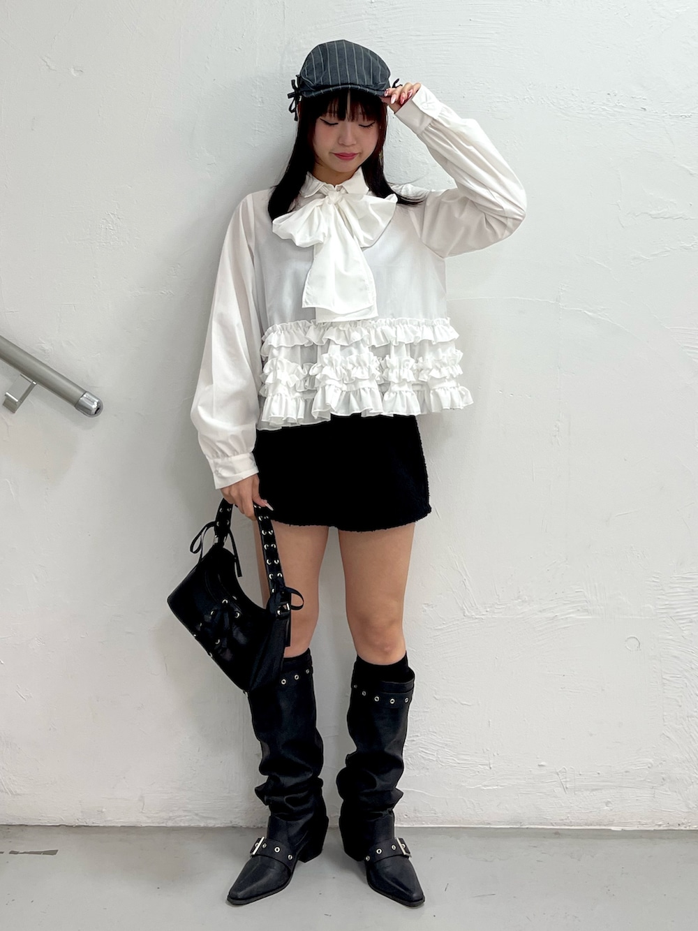 ホワイト系のシャツ/ブラウス、ブラック系のハンドバッグ、ブラック系のブーツを着用したレディースの冬コーディネートの2枚目の写真