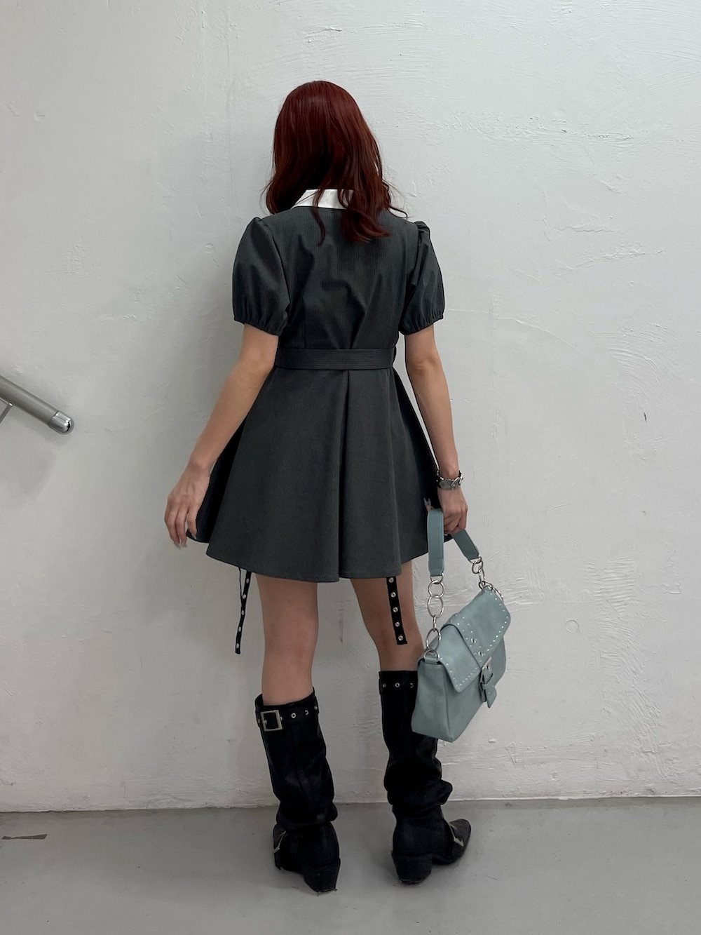グレー系のワンピース、ブルー系のハンドバッグ、ブラック系のブーツを着用したレディースの夏コーディネートの4枚目の写真