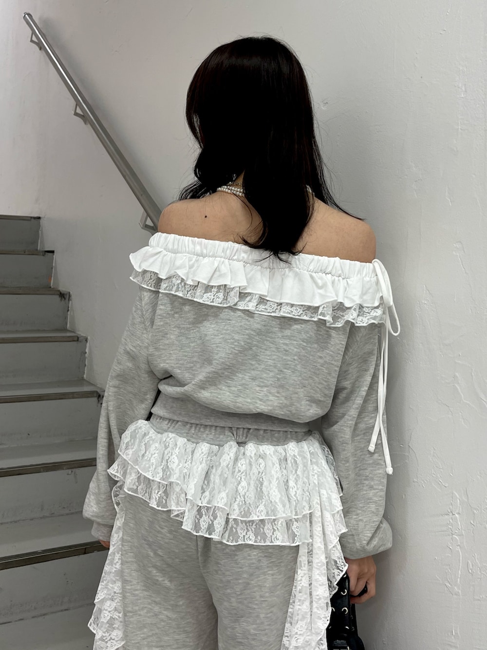 グレー系のスウェット、グレー系のスウェットパンツ、ブラック系のハンドバッグを着用したレディースの冬コーディネートの7枚目の写真