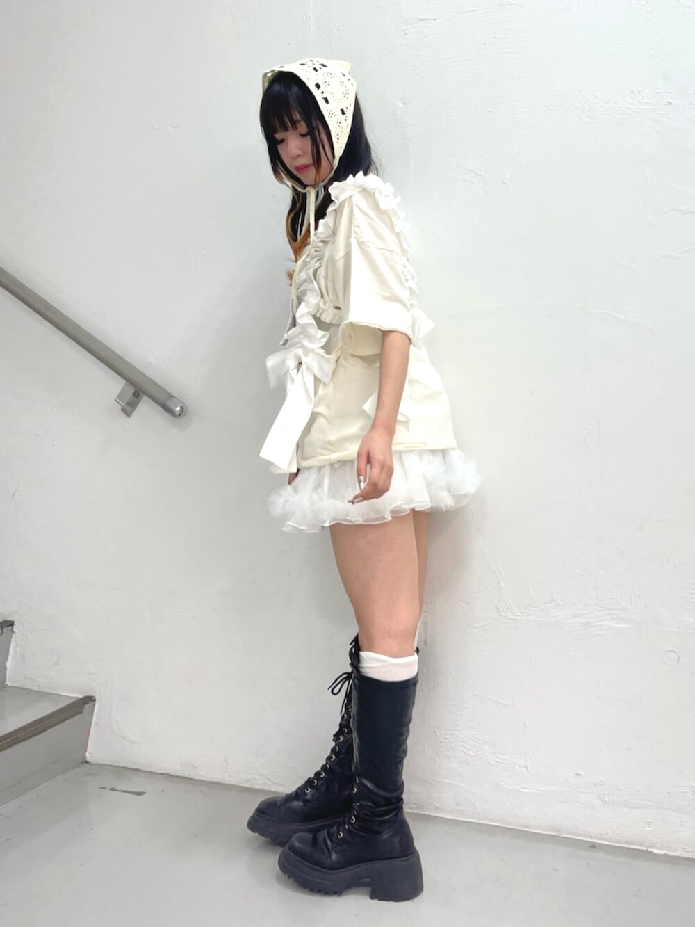 ブラック系のブーツ、ホワイト系のスカート、ホワイト系のTシャツ/カットソーを着用したレディースの夏コーディネートの2枚目の写真