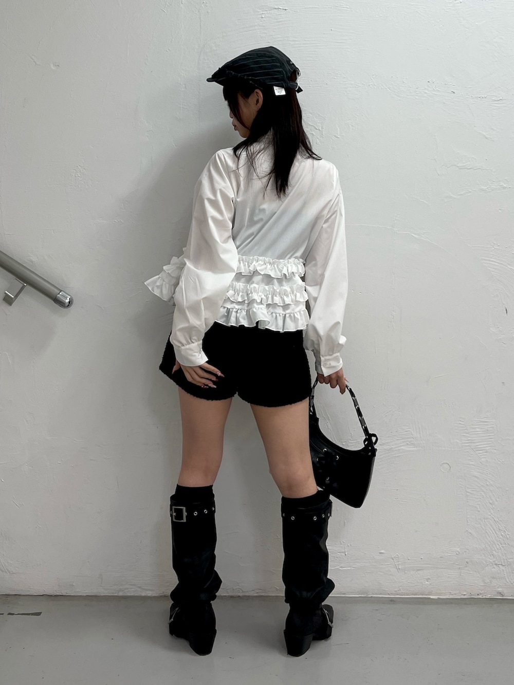 ホワイト系のシャツ/ブラウス、ブラック系のハンドバッグ、ブラック系のブーツを着用したレディースの冬コーディネートの4枚目の写真