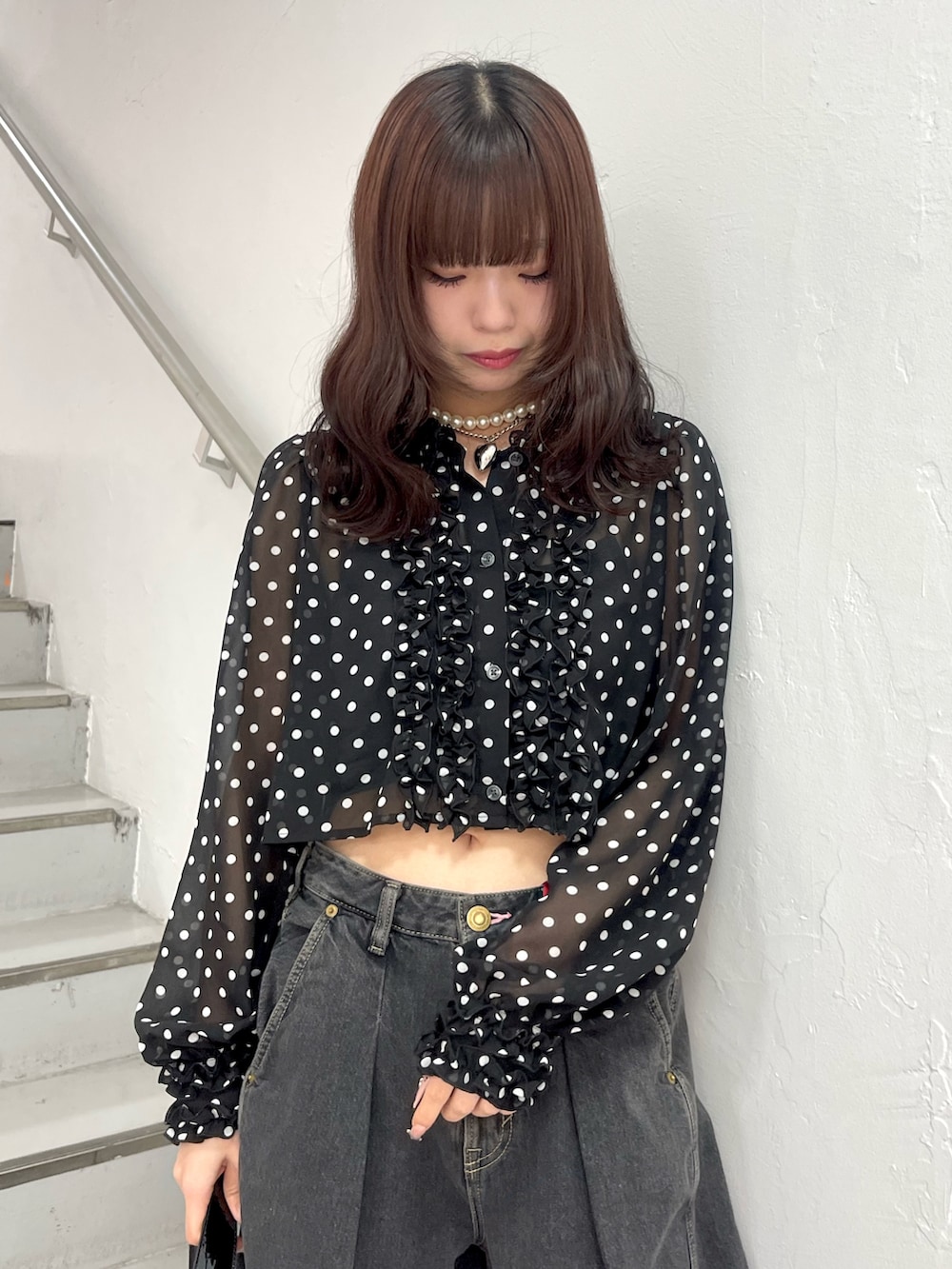 ブラック系のデニムパンツ、ブラック系のハンドバッグ、ブラック系のパンプスを着用したレディースの春コーディネートの5枚目の写真