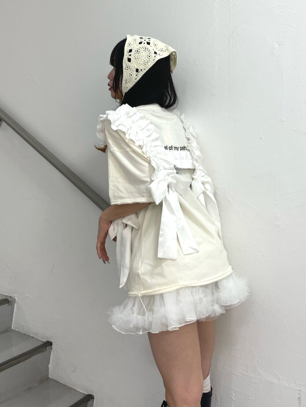 ブラック系のブーツ、ホワイト系のスカート、ホワイト系のTシャツ/カットソーを着用したレディースの夏コーディネートの5枚目の写真