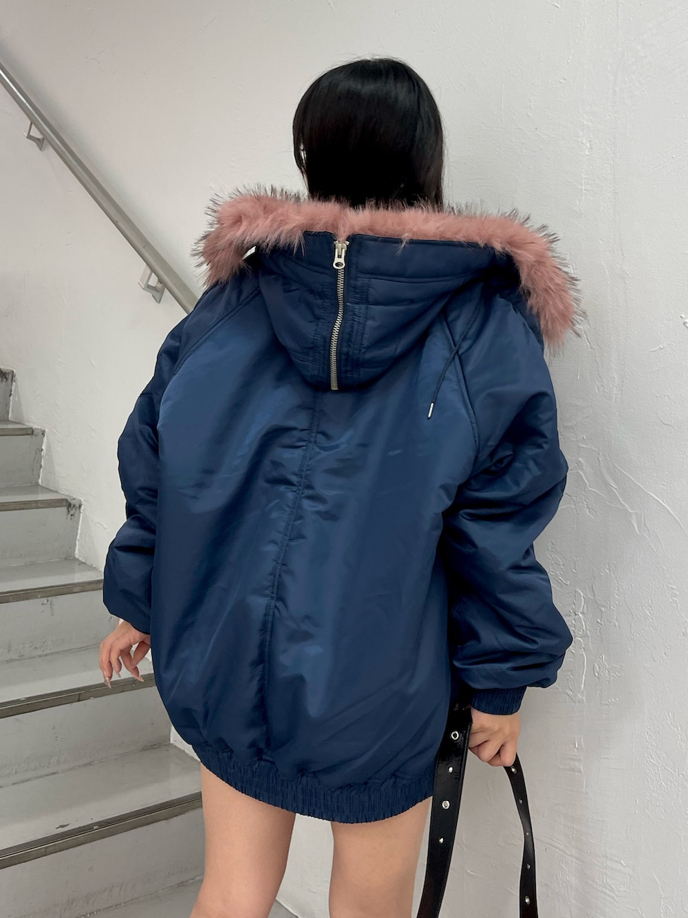 ブルー系のブルゾン、ブラック系のショルダーバッグ、ブラック系のブーツを着用したレディースの秋コーディネートの5枚目の写真