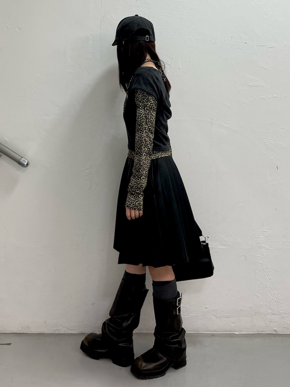 ブラック系のTシャツ/カットソー、ブラック系のスカート、ブラック系のハンドバッグを着用したレディースの冬コーディネートの3枚目の写真