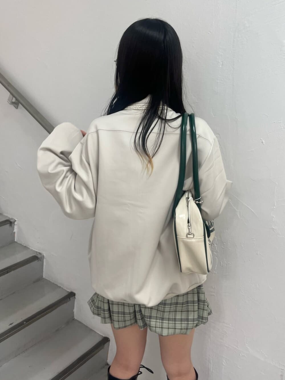 ホワイト系のジャージ、グリーン系のスカート、ホワイト系のボストンバッグを着用したレディースの秋コーディネートの6枚目の写真