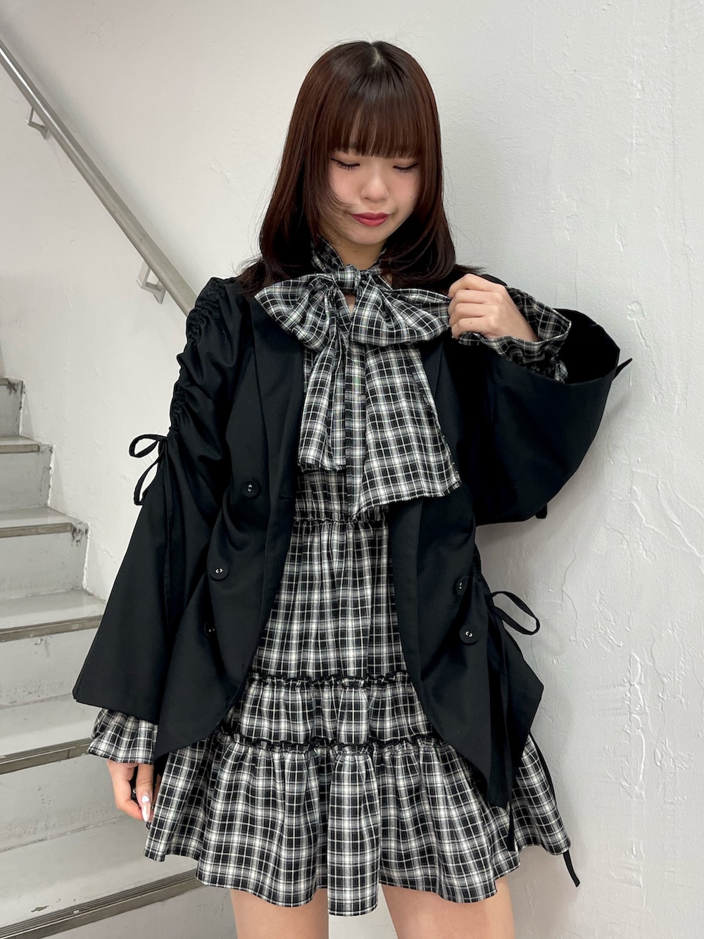 ブラック系のテーラードジャケット、ブラック系のワンピース、ブラック系のブーツを着用したレディースの冬コーディネートの5枚目の写真