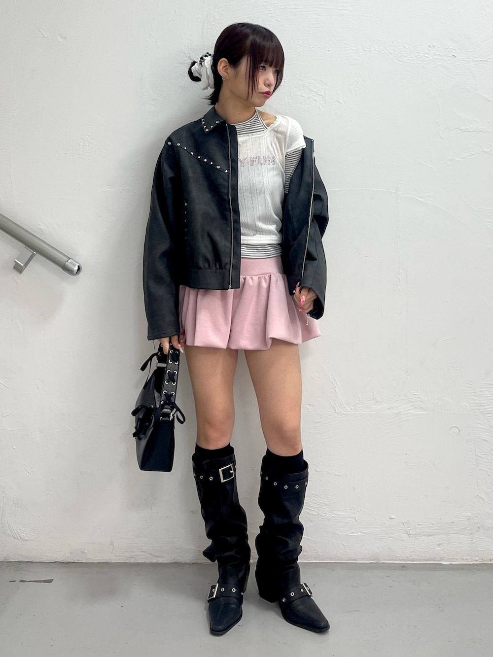 ブラック系のブルゾン、ホワイト系のTシャツ/カットソー、ピンク系のスカートを着用したレディースの冬コーディネートの2枚目の写真