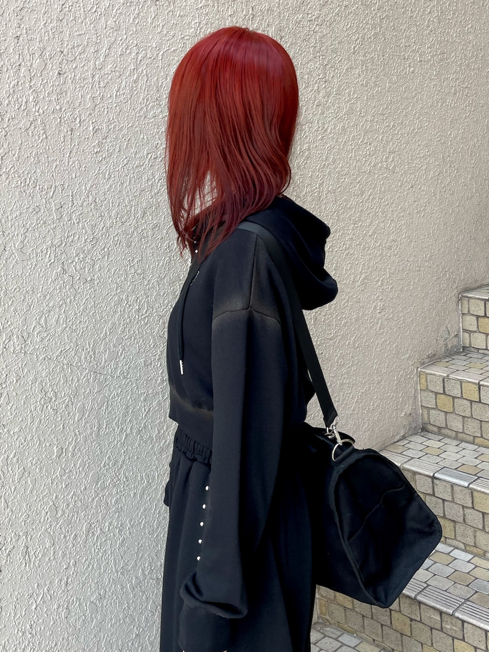 ブラック系のパーカー、ブラック系のスウェットパンツ、ブラック系のボストンバッグを着用したレディースの春コーディネートの6枚目の写真