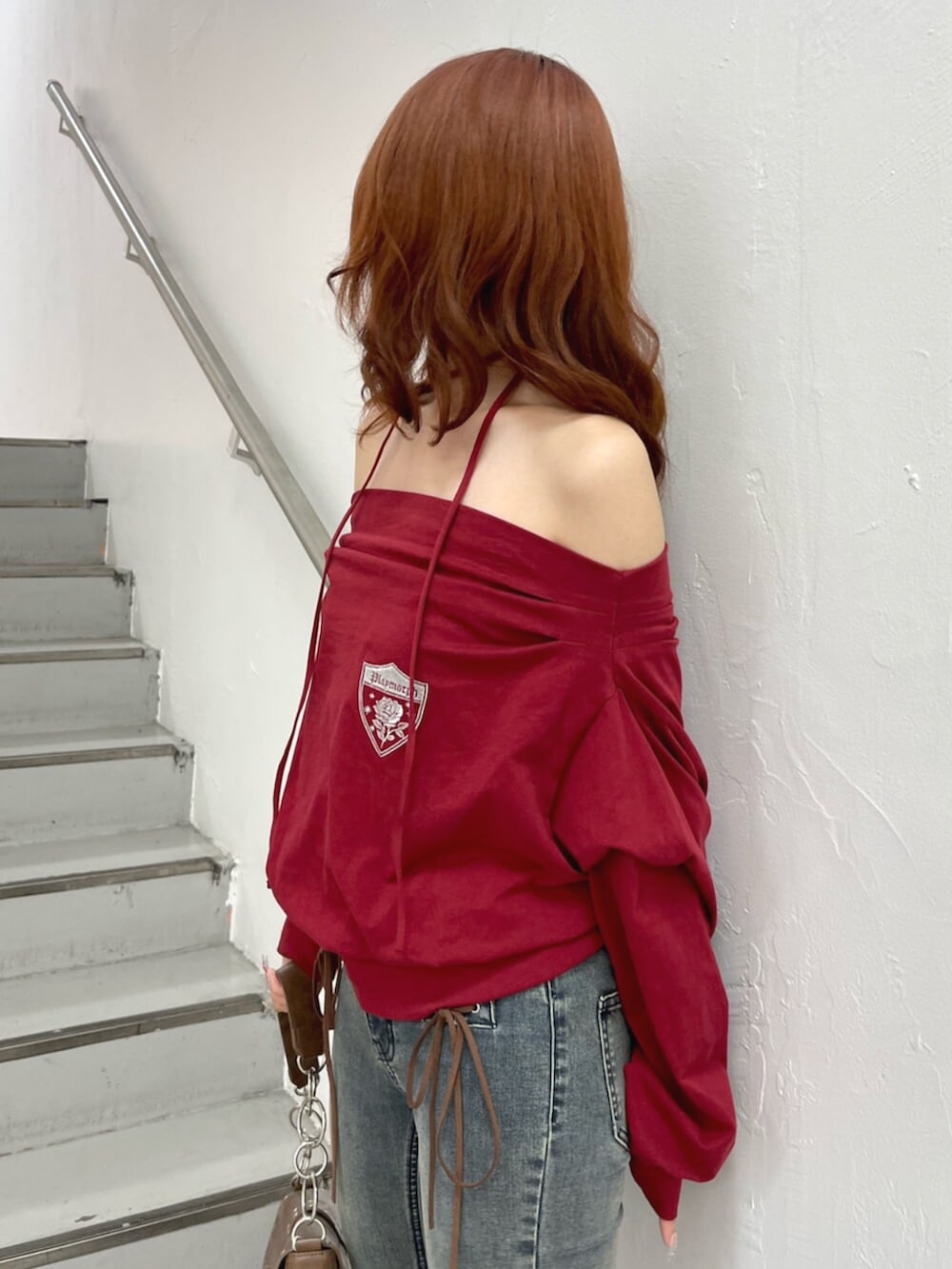 ブラック系のパンプス、ブラウン系のハンドバッグ、レッド系のTシャツ/カットソーを着用したレディースの夏コーディネートの6枚目の写真