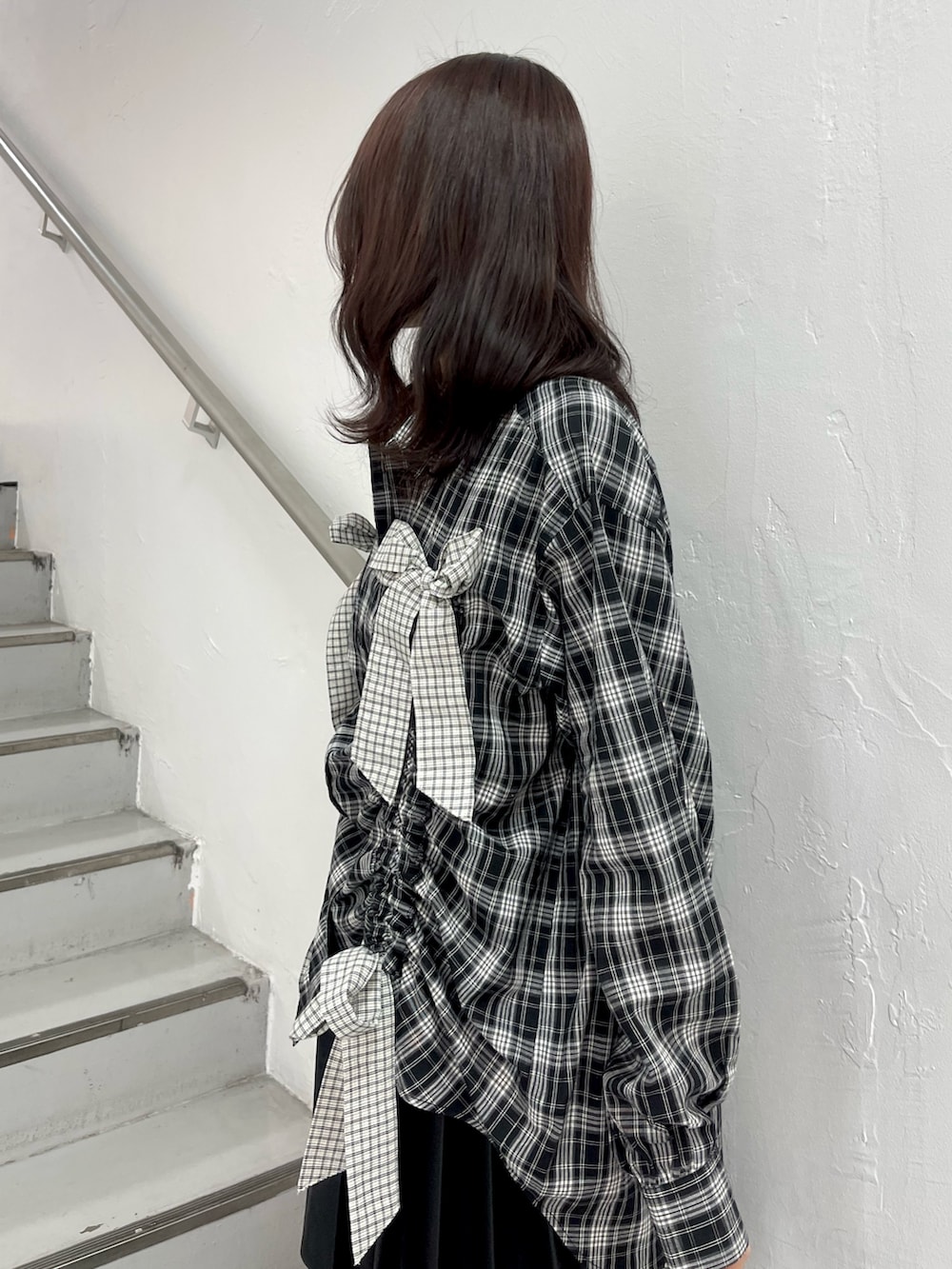 ブラック系のシャツ/ブラウス、ブラック系のスカート、ブラック系のブーツを着用したレディースの春コーディネートの6枚目の写真