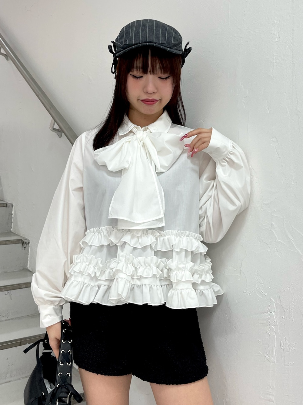 ホワイト系のシャツ/ブラウス、ブラック系のハンドバッグ、ブラック系のブーツを着用したレディースの冬コーディネートの5枚目の写真