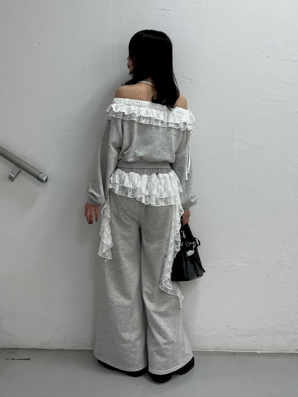 グレー系のスウェット、グレー系のスウェットパンツ、ブラック系のハンドバッグを着用したレディースの冬コーディネートの4枚目の写真