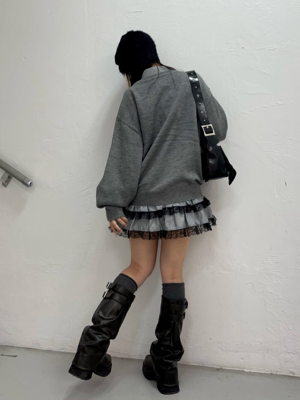 グレー系のニット/セーター、ブラック系のシャツ/ブラウス、ブラック系のブーツを着用したレディースの秋コーディネートの3枚目の写真