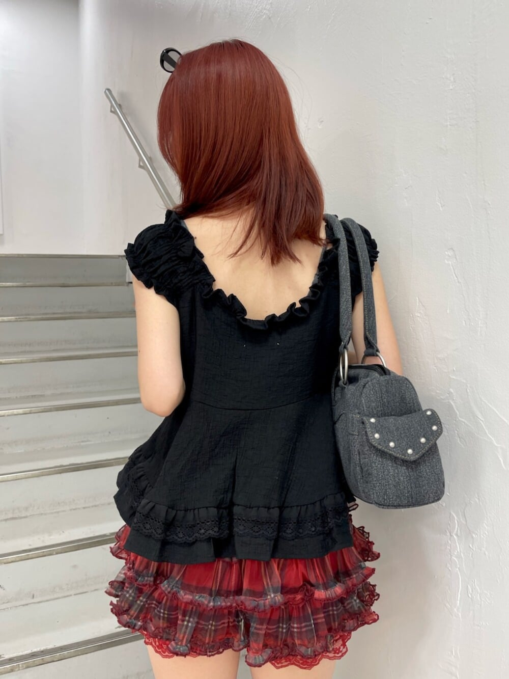 レッド系のその他パンツ、ブラック系のブーツ、ブラック系のボストンバッグを着用したレディースの夏コーディネートの7枚目の写真