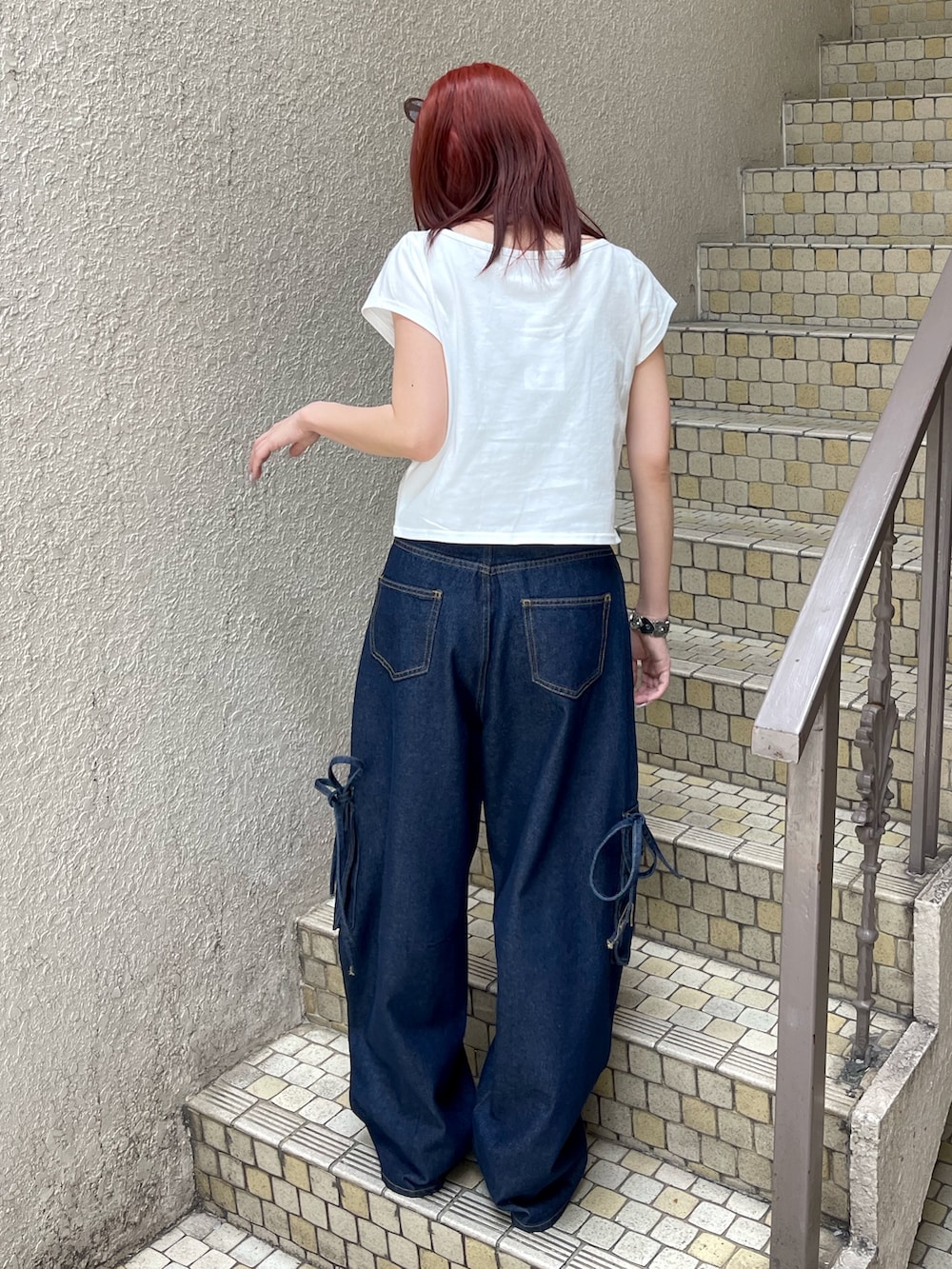 ブルー系のデニムパンツ、ホワイト系のTシャツ/カットソー、ブラック系のパンプスを着用したレディースの春コーディネートの4枚目の写真