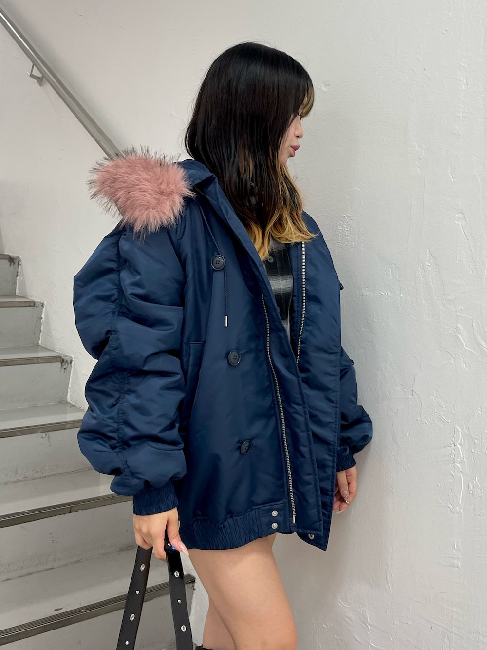 ブルー系のブルゾン、ブラック系のショルダーバッグ、ブラック系のブーツを着用したレディースの秋コーディネートの6枚目の写真