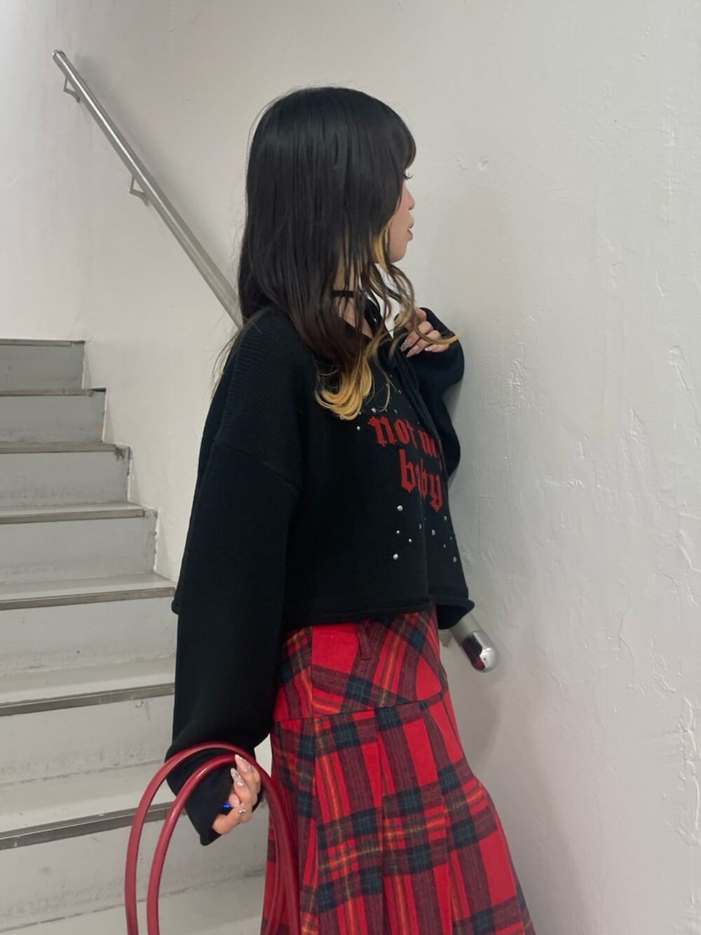 ブラック系のボストンバッグ、ブラック系のブーツ、ブラック系のニット/セーターを着用したレディースの秋コーディネートの5枚目の写真