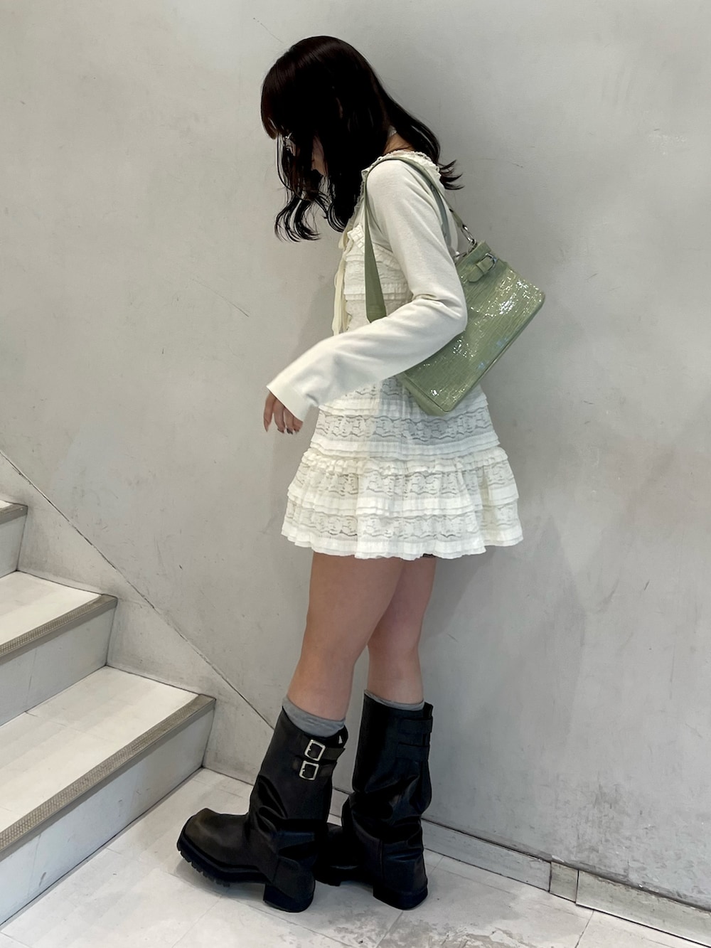 ホワイト系のワンピース、ホワイト系のニット/セーター、グリーン系のハンドバッグを着用したレディースの冬コーディネートの3枚目の写真