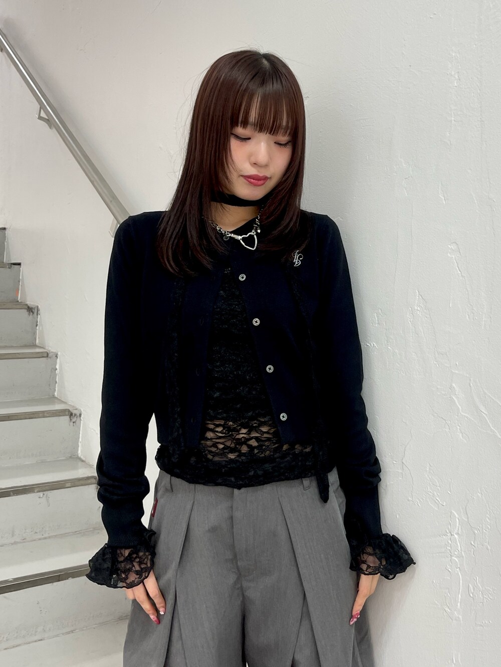 ブラック系のカーディガン/ボレロ、ブラック系のTシャツ/カットソー、グレー系のスラックスを着用したレディースの冬コーディネートの5枚目の写真