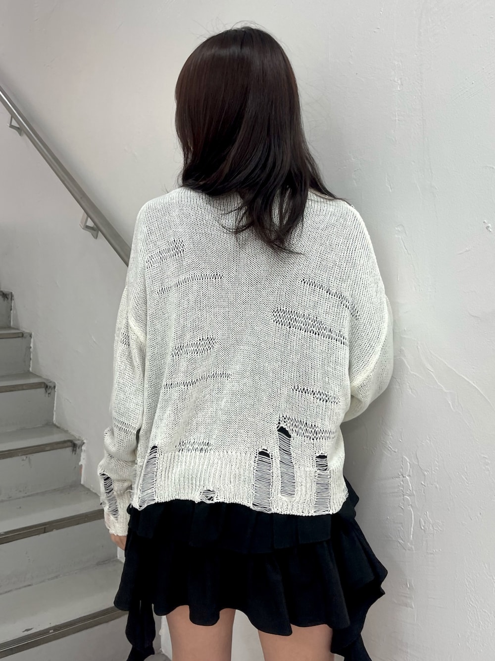 ホワイト系のニット/セーター、ブラック系のシャツ/ブラウス、ブラック系のブーツを着用したレディースの春コーディネートの7枚目の写真