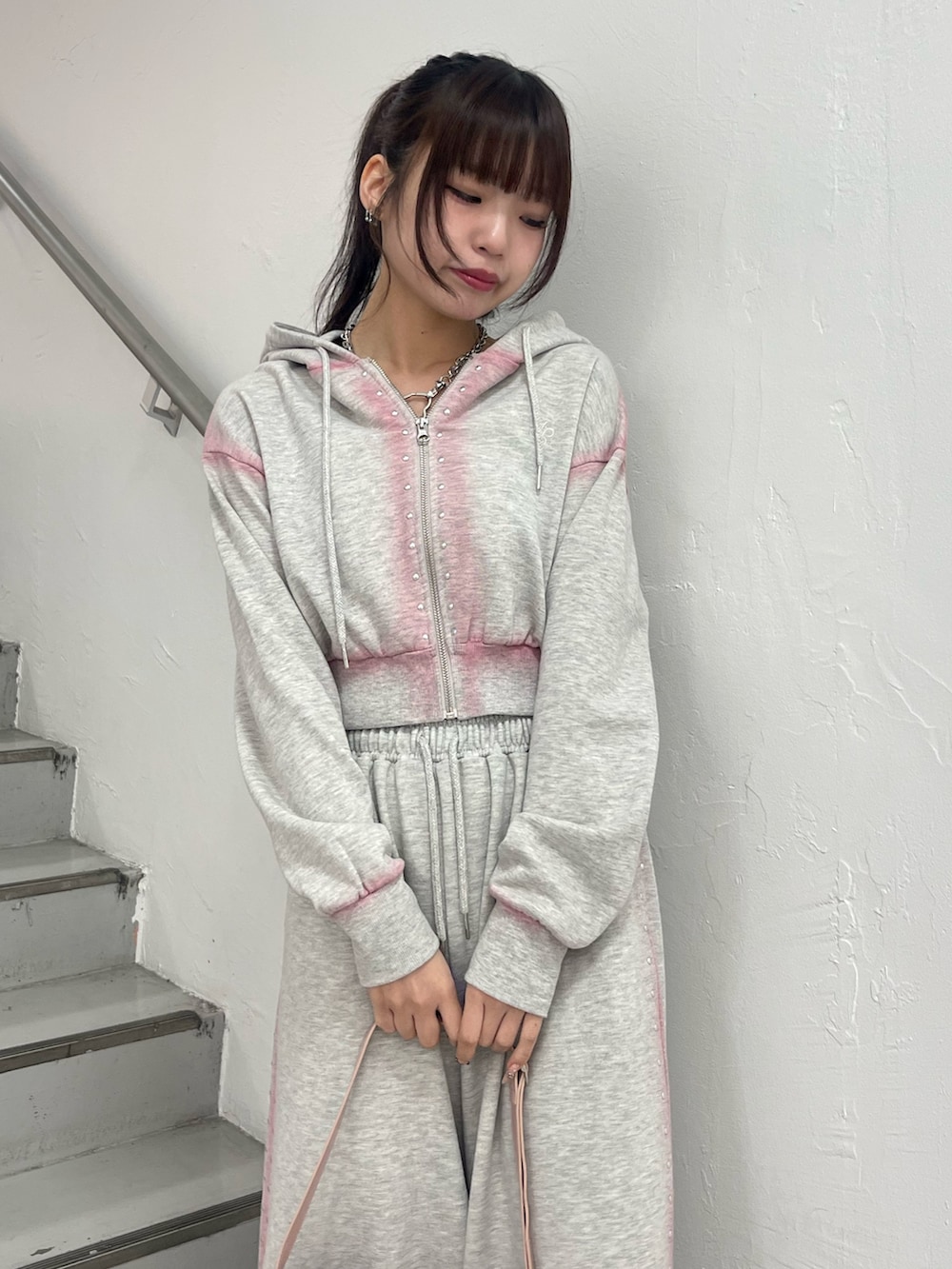 グレー系のスウェットパンツ、グレー系のパーカー、ブラック系のハンドバッグを着用したレディースの春コーディネートの5枚目の写真