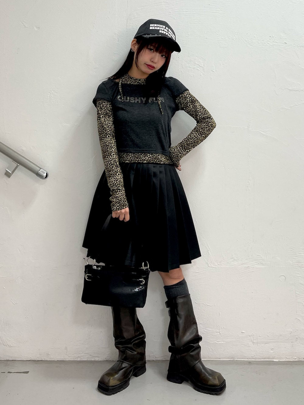 ブラック系のTシャツ/カットソー、ブラック系のスカート、ブラック系のハンドバッグを着用したレディースの冬コーディネートの2枚目の写真